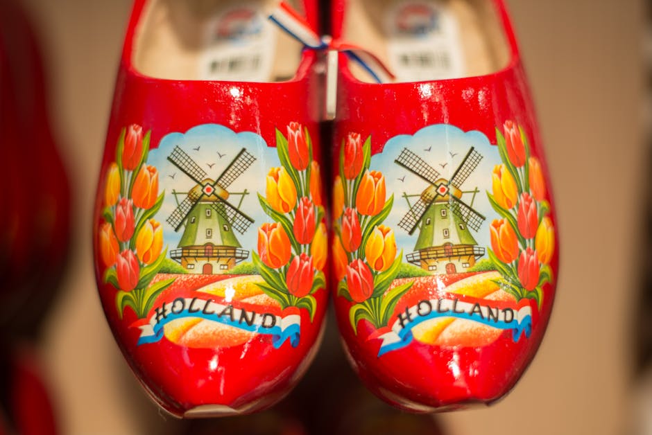 Close-up of traditional Dutch wooden shoes featuring a detailed windmill and tulips design.